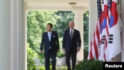 Presiden AS Joe Biden dan Presiden Korea Selatan Yoon Suk Yeol berjalan menuju area Rose Garden di Gedung Putih, Washington, pada 26 April 2023. (Foto: Reuters/Leah Millis)