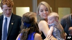 FILE - Saoirse Kennedy Hill, right, granddaughter of Ethel Kennedy and the late Robert F. Kennedy, holds a relative's baby before a ceremony at the John F. Kennedy Presidential Library, in Boston, Sept. 20, 2016. 