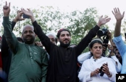 FILE - Manzoor Pashteen, center, leader of Pakistan’s Pashtun Tahafuz Movement, waves to his supporters during a rally in Lahore, Pakistan, April 22, 2018.