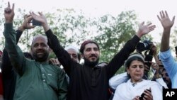 FILE - Manzoor Pashteen, center, leader of Pakistan’s Pashtun Tahafuz Movement (PTM), waves to his supporters during a rally in Lahore, Pakistan, April 22, 2018. 