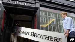 The Lehman Brothers corporate sign in polished metal is taken into an auction house in London, Friday, Sept. 24, 2010.