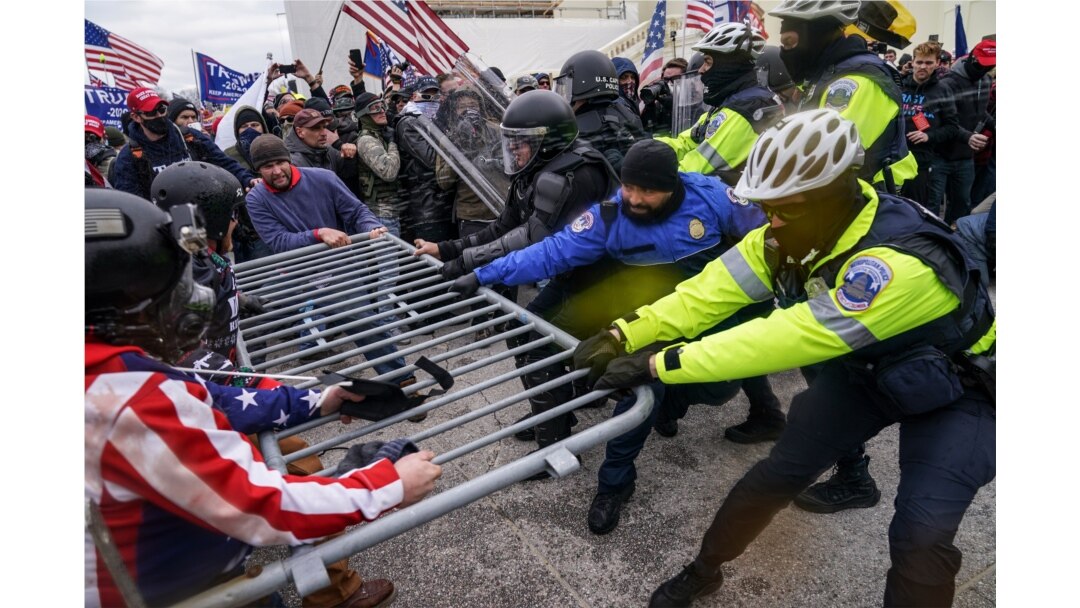 Trump supporters try to break through a police barrier, Jan. 6, 2021, at the Capitol in Washington.