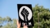 A protester holds up a Black Lives Matter sign outside the police station in Florissant, Mo., June 10, 2020.