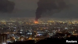 نمایی عمومی از تهران که آتش‌سوزی و دود برخاسته از حمله به یکی از اهداف (احتمالاً فرودگاه مهرآباد) را نشان می‌دهد.