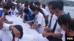 Para pelajar di Bali membubuhkan tanda tangan dalam peringatan pengeboman Bali 2005.(VOA/Muliarta)