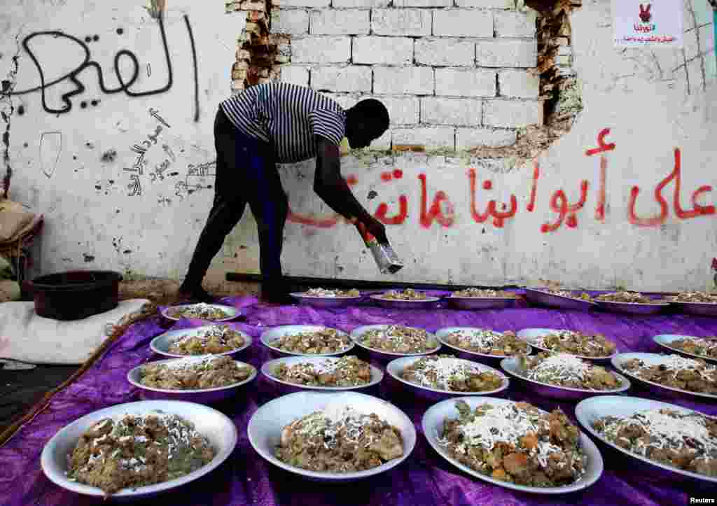 Seorang pengunjuk rasa Sudan menyajikan makanan berbuka puasa pada hari pertama Ramadan di depan kompleks Kementerian Pertahanan di Khartoum, Sudan, 6 Mei 2019. (Foto: Reuters/Mohamed Nureldin Abdallah)