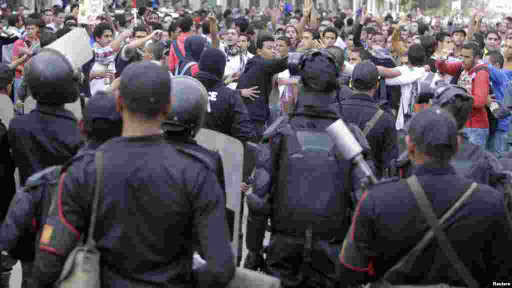 Cairo University students shout slogans against the military and Interior Ministry in front of riot police at the main gate of the university, Cairo, Nov. 24, 2013.