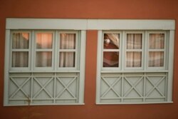 A man looks out of a window at the H10 Costa Adeje Palace hotel in La Caleta, in the Canary island of Tenerife, Spain, Feb. 26, 2020. Spanish officials say a tourist hotel in Tenerife has been placed in quarantine.