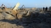 Palestinians inspect site of Israeli air strike in southern Gaza Strip, June 14, 2019. 