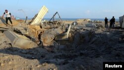 Palestinians inspect site of Israeli air strike in southern Gaza Strip, June 14, 2019. 