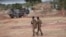Des soldats burkinabè patrouillent près d'un véhicule blindé français stationné à Kaya, capitale de la région du centre-nord du Burkina Faso, le 20 novembre 2021.