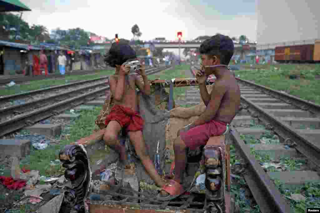 Children act out taking pictures with a non-functioning camera in Dhaka, Bangladesh, Sept. 16, 2019. 