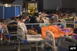 Patients breathe with the help of oxygen masks inside a banquet hall temporarily converted into a Covid-19 coronavirus ward in New Delhi, India, April 27, 2021.