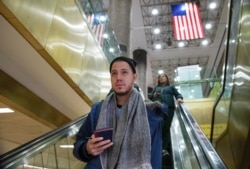 Martín Batalla Vidal takes an escalator into the Port Authority Bus Terminal in New York to take a bus to Washington, Nov. 11, 2019.