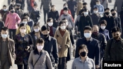 People wearing protective face masks commute amid concerns over the new coronavirus disease (COVID-19) in Pyongyang, North Korea March 30, 2020