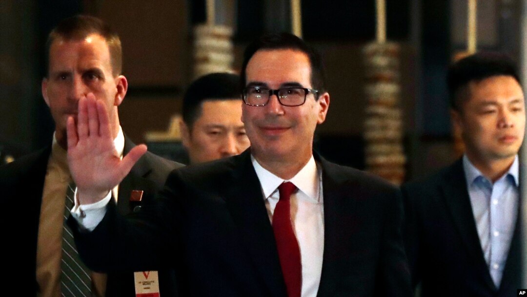 Bộ Trưởng Thương Mại Mỹ Steven Mnuchin, ở giữa, vẫy tay chào các nhà báo khi ông về tới khách sạn sau một cuộc gặp gỡ với các quan chức TQ ở Bắc Kinh hôm 3/5/2018. (AP Photo/Andy Wong)