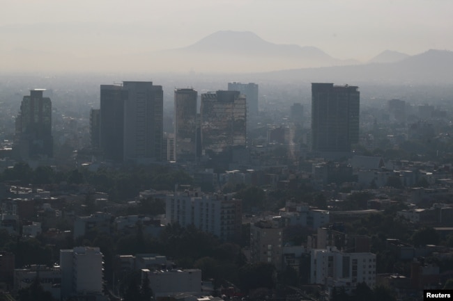 Buildings and houses stand shrouded in smog as authorities ordered traffic restrictions due to air pollution in Mexico City, Mexico, March 7, 2024. (REUTERS/Henry Romero)