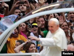 El papa Francisco saluda a una multitud de fieles desde su papamóvil en el centro de Río de Janeiro el 22 de julio de 2013 en su primer viaje al extranjero como pontífice y una serie de eventos de una semana que se espera atraigan a más de un millón de feligreses en Brasil.