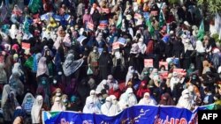 FILE - Jamaat-e-Islami activists and supporters take part in an anti-India demonstration in Lahore, Pakistan, Feb. 5, 2021. India said on Sunday it raided dozens of places linked to the group in Jammu and Kashmir. 