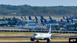 Un avión de Copa Airlines es visto en una pista mientras otro aterriza del aeropuerto internacional de Tocumen, el 22 de marzo de 2020.