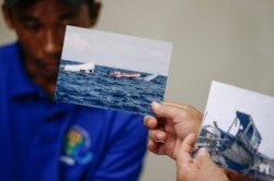 Photos of the damaged Filipino fishing vessel F/B Gimver 1 is shown next to one of its crew Richard Blaza during a press conference by Department of Agriculture Secretary Emmanuel Pinol in metropolitan Manila, Philippines, June 17, 2019.