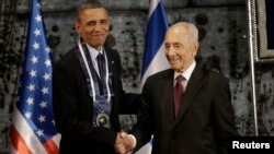 President Barack Obama shakes hands with Israeli President Shimon Peres after Peres presented him with the Israeli Medal of Distinction at a state dinner in Jerusalem on March 21, 2013.