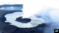 FILE - This Sunday, Oct. 1, 2017 photo provided by GeoHazards Divison, Vanuatu Meteorological and GeoHazards Department, shows an aerial view of the volcanic cone that has formed in Lake Vui near the summit of Ambae Island, Vanuatu. (Brad Scott/GeoHazards Divison, VMGD via AP)