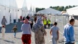(FILE) Afghan refugees walk through an Afghan refugee camp at Joint Base McGuire Dix Lakehurst, N.J., on Sept. 27, 2021.