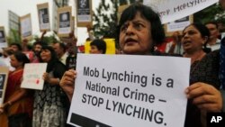 Peserta unjuk rasa di India memegang poster-poster dan meneriakkan slogan-slogan untuk menentang kekerasan massal di Ahmadabad, India, 23 Juli 2018.