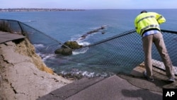 Public Services Director Bill Riccio look down at the destruction along the historic Cliff Walk on March 15, 2022 in Newport, Rhode Island. (AP Photo/Charles Krupa)