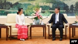 Chinese President Xi Jinping (R) meets Myanmar's pro-democracy leader Aung San Suu Kyi at the Great Hall of the People in Beijing on June 11, 2015.