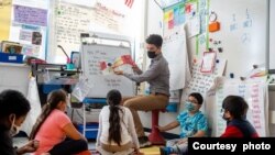 El maestro sustituto Julian Consolla es visto con estudiantes en la escuela primaria Mount Eagle, en Alexandria, condado de Fairfax, Virginia. (Cortesía de Donnie Biggs, Escuelas Públicas del Condado de Fairfax).