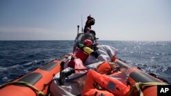 Une équipe de Proactiva Open Arms effectue une opération de recherche et de sauvetage de migrants en Méditerranée, à 12 milles nautiques de la côte libyenne, le jeudi 13 avril 2017. 