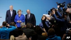 German Chancellor Angela Merkel is flanked by Bavarian governor Horst Seehofer (L) and Social Democratic Party Chairman Martin Schulz as they pose for a photo after the exploratory talks between Merkel's Christian Democratic block and the Social Democrats on forming a new German government in Berlin, Germany, Jan. 12, 2018. 