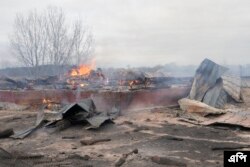 Asap dan api mengepul dari puing-puing sebuah rumah pribadi setelah penembakan Rusia di luar Kyiv, Ukraina, Kamis, 24 Februari 2022. (AP/Efrem Lukatsky)