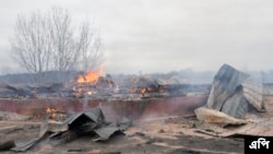 우크라이나 수도 키예프 외곽 주택가에서 24일 포격 직후 화재가 진행되고 있다.