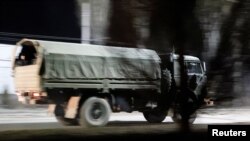 Sebuah truk militer melaju di jalanan Donetsk, Ukraina, setelah Presiden Rusia Vladimir Putin memerintahkan pengerahan pasukan Rusia ke dua wilayah yang memisahkan diri di Ukraina timur menyusul pengakuan kemerdekaan mereka, 22 Februari 2022. (REUTERS/Alexander Ermochenko)