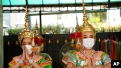 FILE - Thai traditional dancers wearing face masks to help protect themselves from the coronavirus perform at the Erawan Shrine in Bangkok, Thailand, Feb. 7, 2022. 