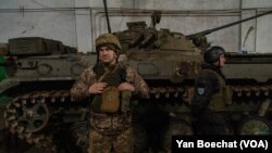 Ukrajinski vojnik stražali pored oklopnog vozila u gradu Novolugansk, nekoliko kilometara udaljenom od linije fronta, u istočnoj Ukrajini, 19. febraura 2022. (Yan Boechat/VOA) 