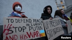 在基辅,活动人士举着标语站在乌克兰外交部前,要求欧盟对俄罗斯实施更多的制裁,以制止普京的侵略。(2022年2月21日)