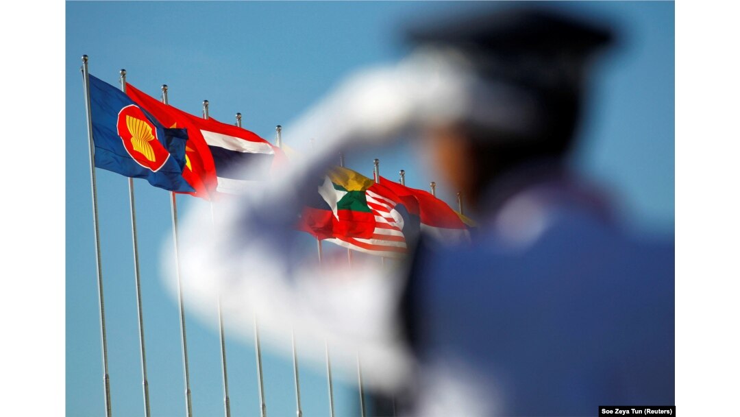Seorang petugas polisi berdiri di dekat bendera nasional negara-negara ASEAN selama KTT ASEAN ke-25 di Pusat Konvensi Internasional Myanmar di Naypyitaw, 12 November 2014. (Foto: REUTERS/Soe Zeya Tun)