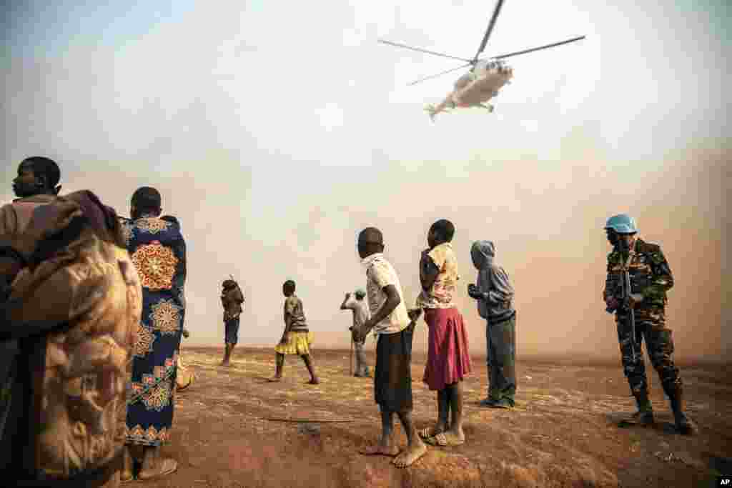 Displaced people watch the United Nations helicopter carrying Under-Secretary-General for Peace Operations Jean Pierre Lacroix (not pictured) land in Bunia, Democratic Republic of Congo, Feb. 22, 2022.