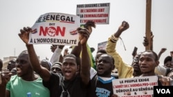 Protesters hold signs calling for an end to homosexuality in Senegal in Dakar, Feb. 20, 2022. (Annika Hammerschlag/VOA)