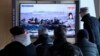 People watch a TV report on the crisis in Ukraine during a news program at the Seoul Railway Station, in Seoul, South Korea, Feb. 24, 2022.