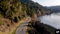 In this aerial image taken from a drone, a pedestrian walks near End of Road on Jan. 19, 2022, where Emmilee Risling was last seen before going missing in October 2021, in Klamath, Calif.