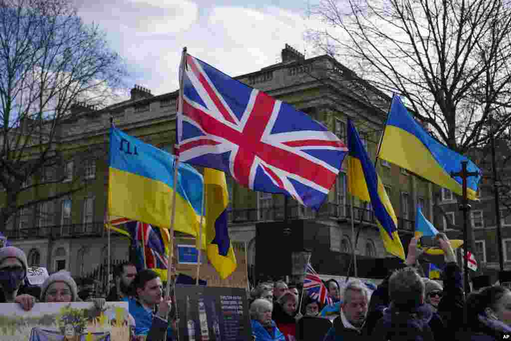 People hold placards, Ukrainian flags and a Union flag as they attend a demonstration outside Downing Street, in London, Feb. 24, 2022. 
