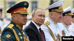 سرگئی شویگو (سمت چپ) وزیر دفاع و سمت راست فرمانده نیروی دریایی روسی در دو طرف رئیس جمهوری روسیه