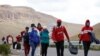 Migrantes venezolanos caminan por una carretera después de cruzar la frontera en las tierras altas entre Bolivia y Chile, en Colchane, Chile 15 de febrero de 2022. 