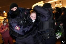 Police officers detain a demonstrator in St. Petersburg, Russia, Thursday, Feb. 24, 2022. Hundreds of people gathered in the centers of Moscow and St.Petersburg on Thursday, protesting against Russia's attack on Ukraine.