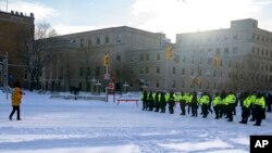 警方在渥太华与反对新冠疫苗强制令的一名抗议者对峙。(2022年2月18日)